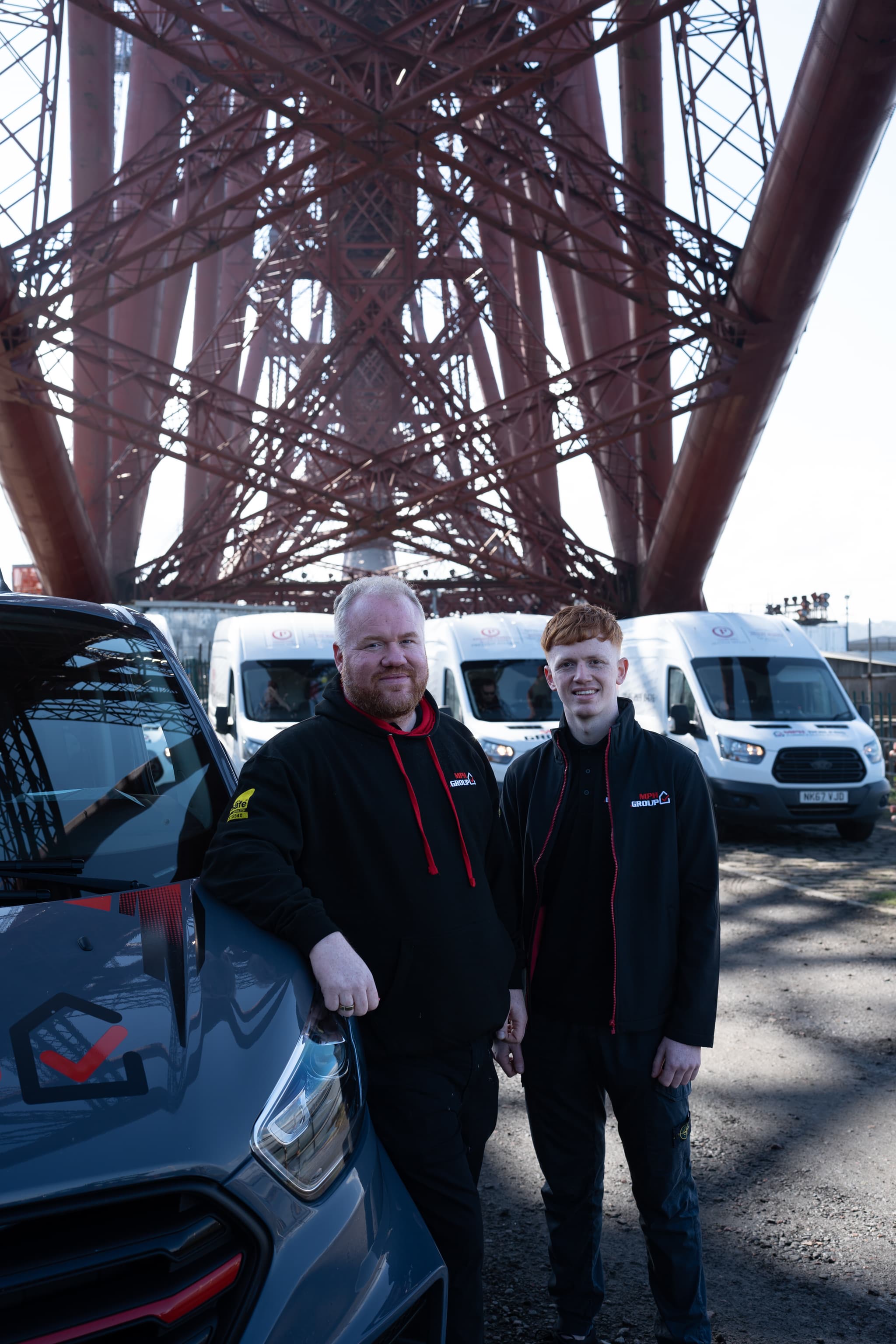 branded MPH Boilers van parked in front of a recognizable Edinburgh or Glasgow landmark, professional heating engineers in uniform
